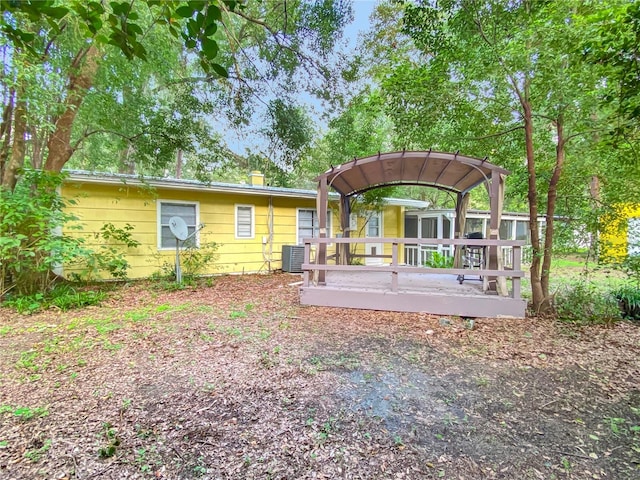 rear view of house featuring cooling unit and a wooden deck