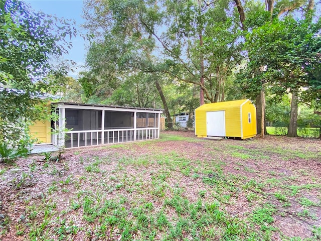 view of yard featuring a sunroom and a shed