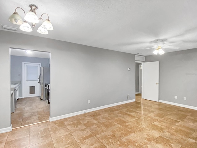 empty room with a textured ceiling, light tile patterned flooring, and ceiling fan with notable chandelier