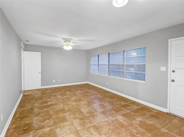 tiled empty room featuring ceiling fan