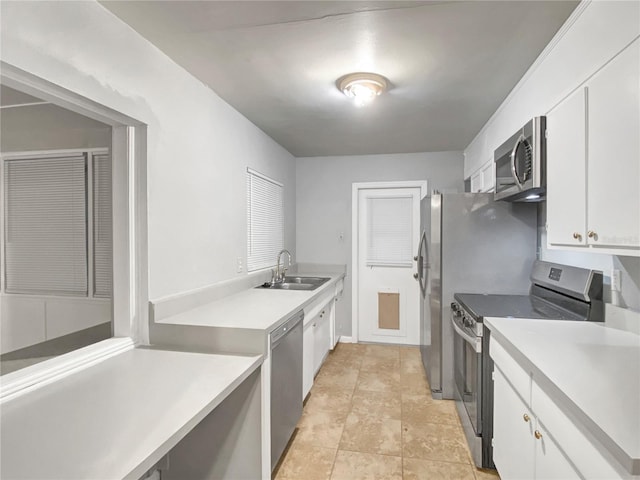 kitchen with white cabinets, stainless steel appliances, light tile patterned floors, and sink