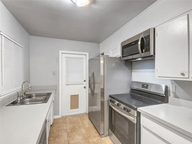 kitchen featuring light tile patterned flooring, sink, appliances with stainless steel finishes, and white cabinets