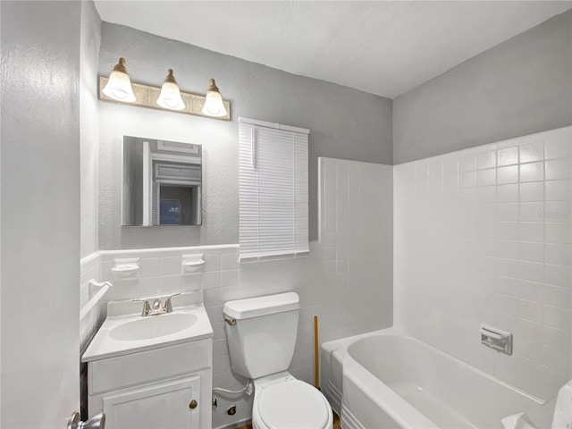 full bathroom featuring vanity, tile walls, tiled shower / bath combo, toilet, and backsplash