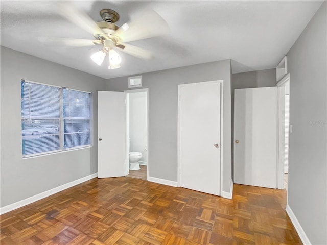 unfurnished bedroom featuring ensuite bath, ceiling fan, and dark parquet flooring