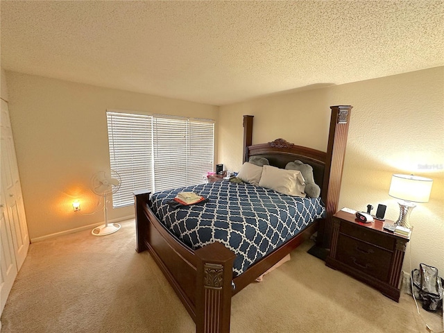 bedroom featuring light carpet and a textured ceiling