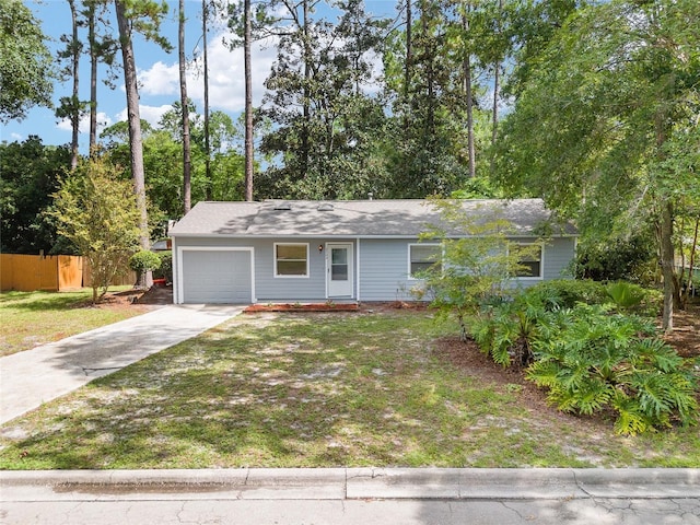 ranch-style house featuring a garage, fence, concrete driveway, and a front yard