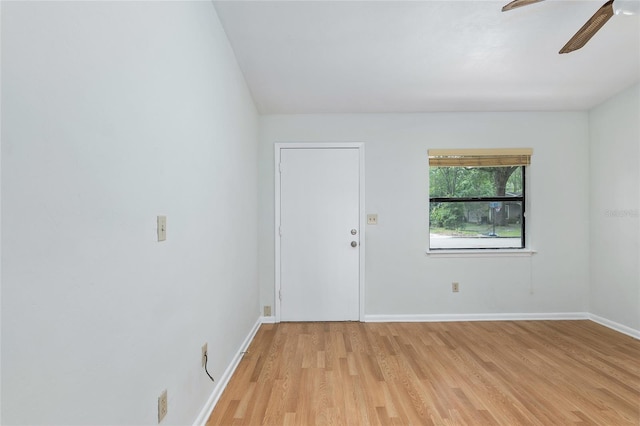 empty room featuring a ceiling fan, baseboards, and light wood finished floors