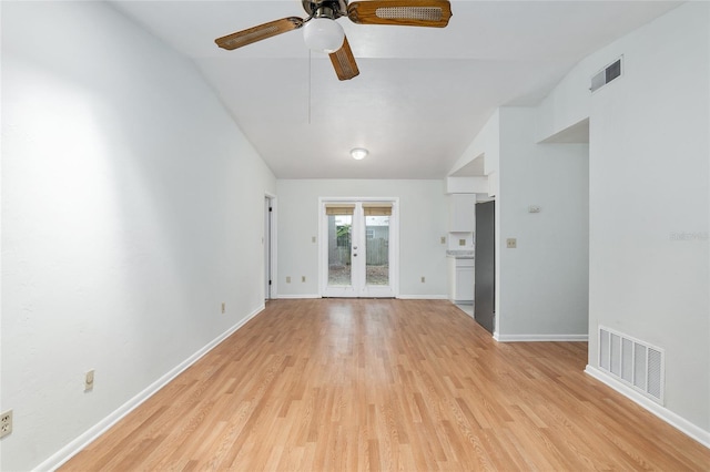 unfurnished living room featuring lofted ceiling, french doors, light wood-style flooring, and visible vents