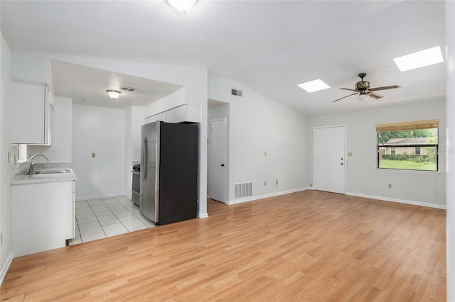 interior space with light countertops, appliances with stainless steel finishes, visible vents, and white cabinets