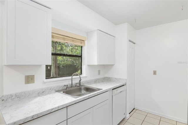 kitchen featuring light tile patterned floors, white cabinets, white dishwasher, a sink, and baseboards