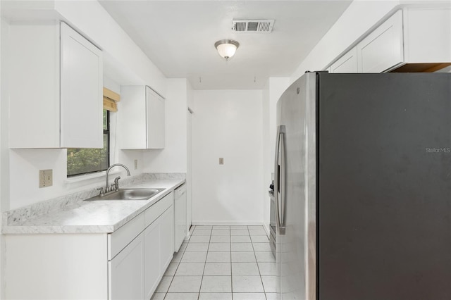 kitchen featuring stainless steel refrigerator with ice dispenser, light countertops, visible vents, white cabinetry, and a sink