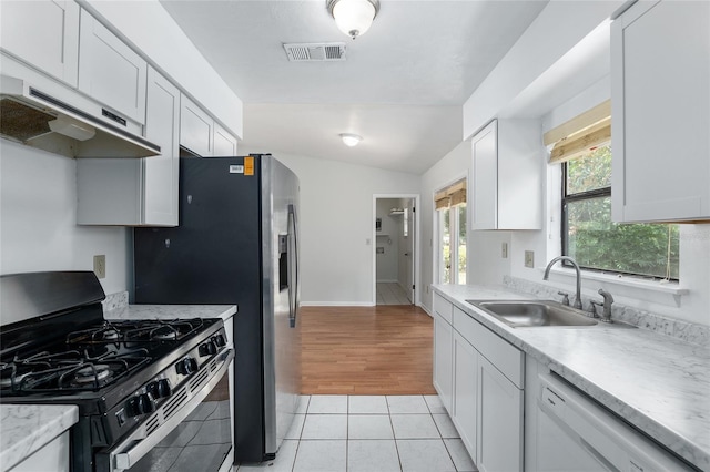 kitchen with black gas range, white cabinets, white dishwasher, light countertops, and a sink