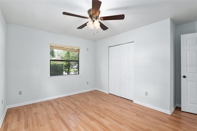 unfurnished bedroom with ceiling fan, a closet, light wood-type flooring, and baseboards