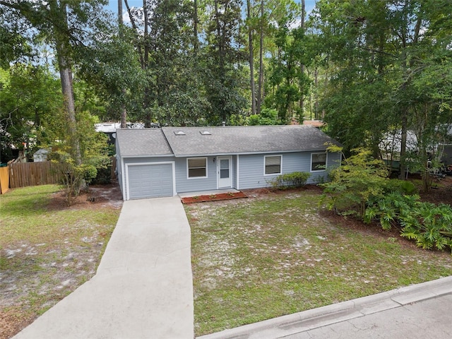 single story home featuring driveway, a front lawn, an attached garage, and fence