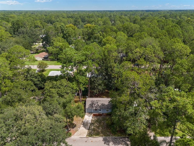 bird's eye view with a wooded view