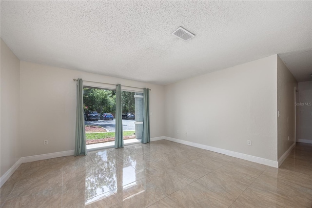 unfurnished room featuring a textured ceiling