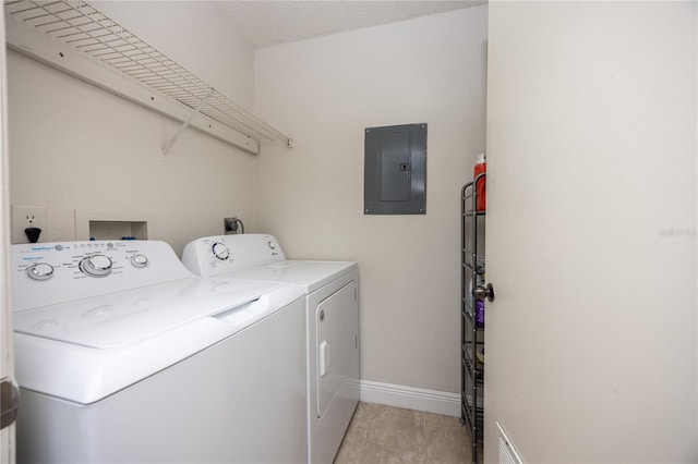 laundry room featuring electric panel, independent washer and dryer, and a textured ceiling