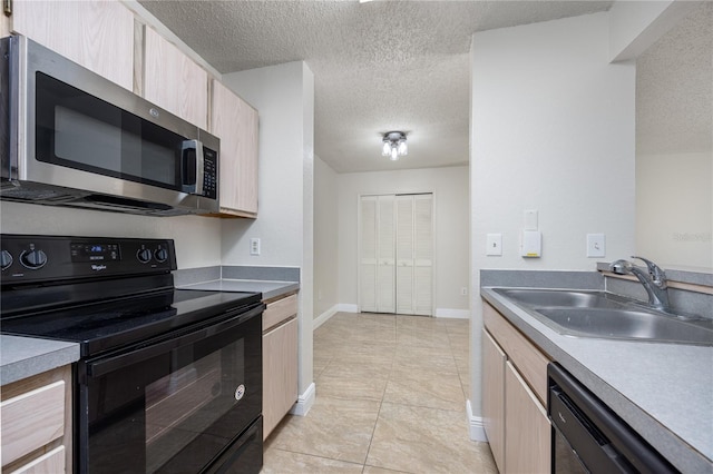 kitchen featuring sink, a textured ceiling, light brown cabinetry, and black appliances