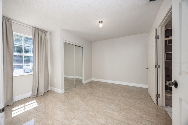 unfurnished bedroom with a closet and a textured ceiling