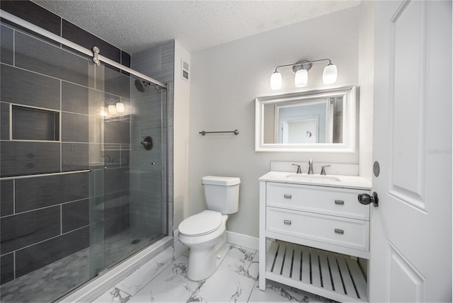 bathroom featuring vanity, a shower with door, toilet, and a textured ceiling