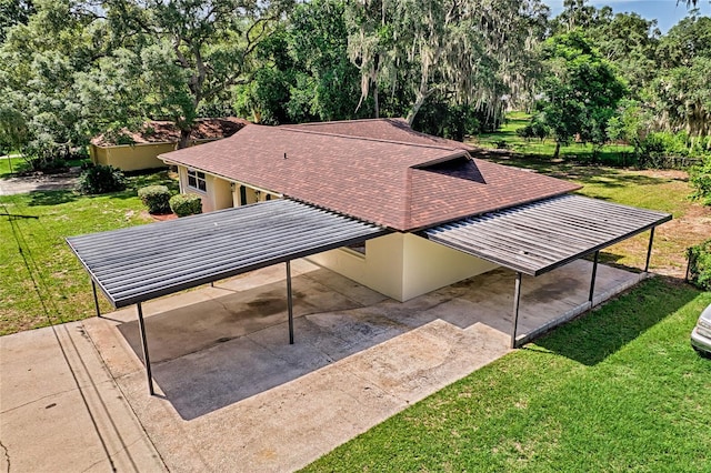 exterior space with a carport and a lawn