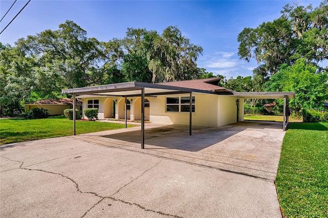 view of front of house with a carport and a front lawn