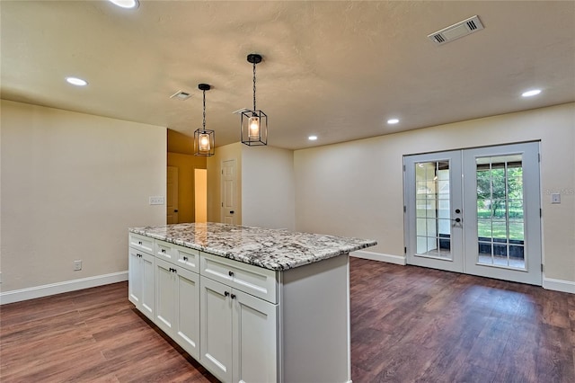 kitchen with white cabinetry, french doors, a center island, pendant lighting, and wood-type flooring