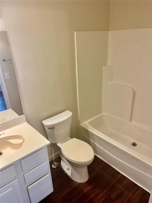 full bathroom featuring vanity, toilet, hardwood / wood-style floors, and shower / washtub combination