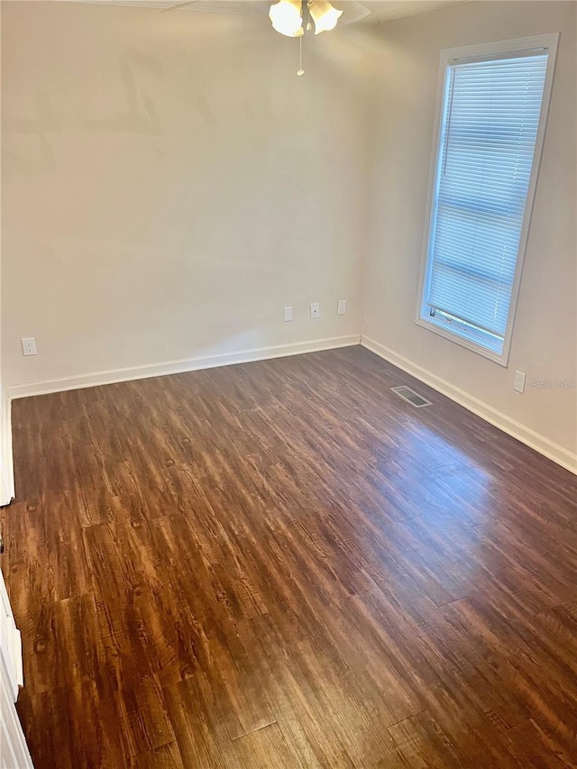 empty room with ceiling fan and dark hardwood / wood-style flooring