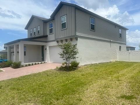 back of property featuring a garage and a yard