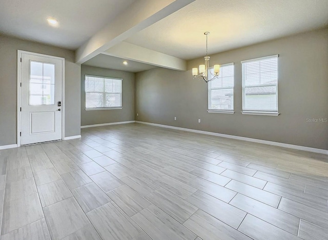 interior space with beamed ceiling and an inviting chandelier