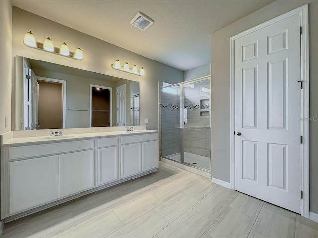 bathroom featuring vanity, a textured ceiling, and walk in shower