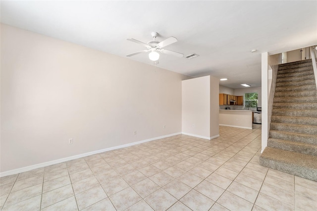 unfurnished room with light tile patterned floors, visible vents, ceiling fan, baseboards, and stairs