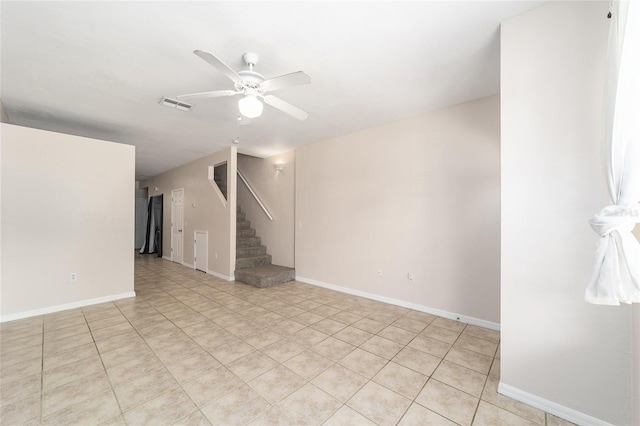 spare room featuring a ceiling fan, visible vents, stairway, and baseboards