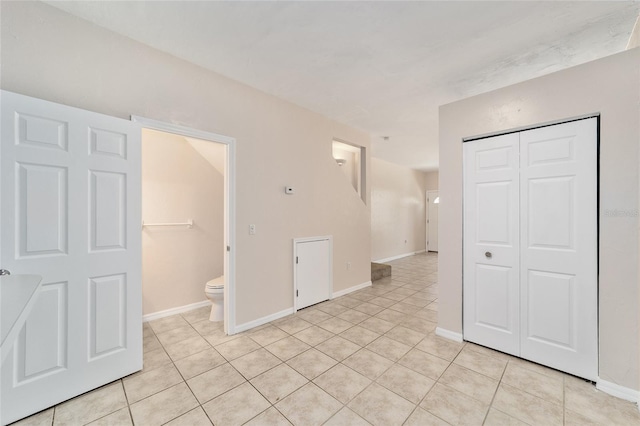 empty room with light tile patterned floors and baseboards