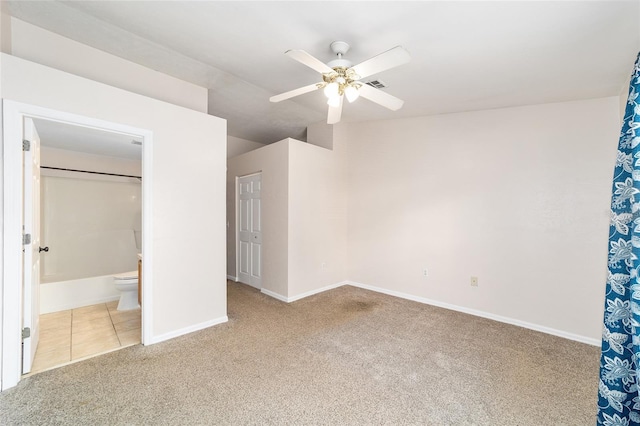 unfurnished bedroom featuring visible vents, baseboards, connected bathroom, tile patterned floors, and carpet