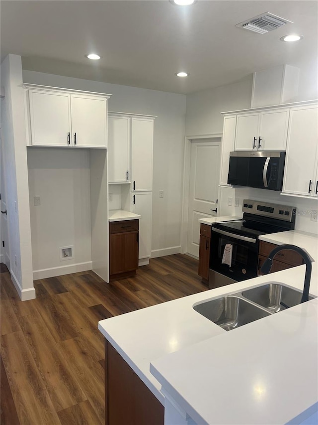 kitchen featuring sink, dark hardwood / wood-style flooring, white cabinetry, and electric stove