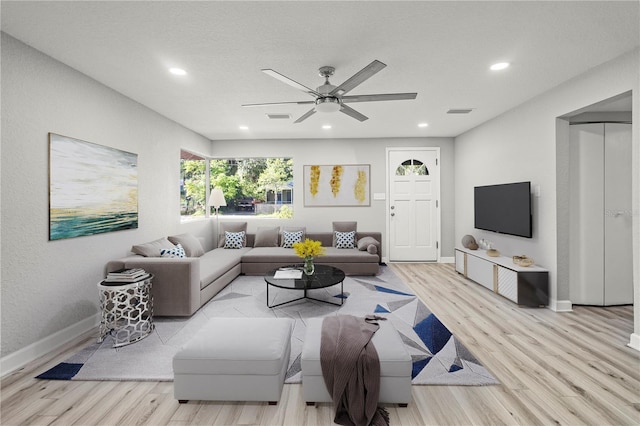 living room featuring light hardwood / wood-style floors and ceiling fan