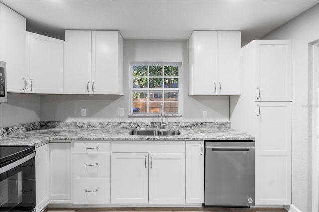 kitchen with white cabinets, dishwasher, light stone counters, and sink