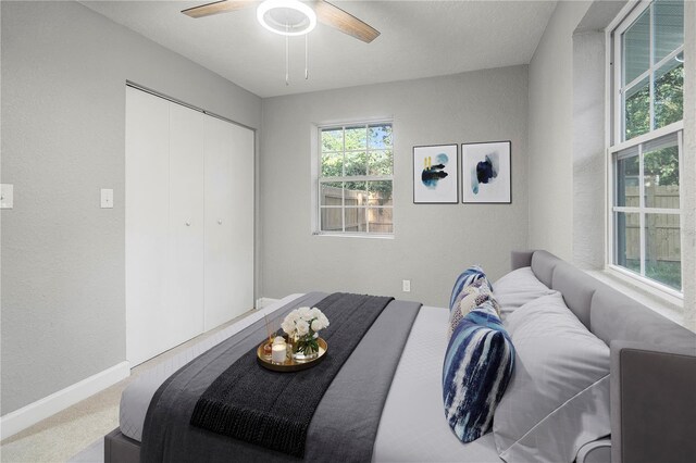 1022 NE 8th Ave, Gainesville, FL 32601 - bedroom with a textured wall, a closet, carpet floors, a ceiling fan, and baseboards