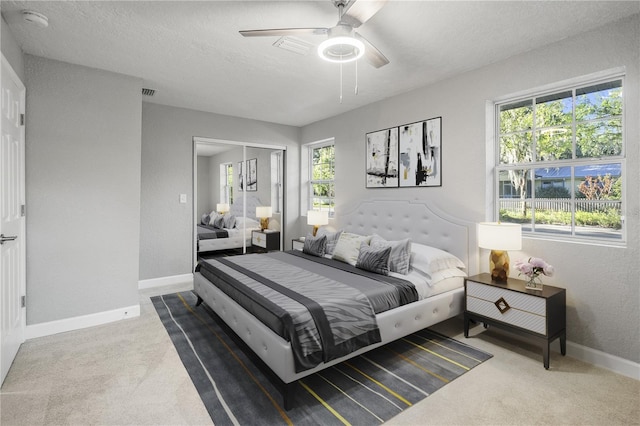 bedroom featuring a textured ceiling, ceiling fan, carpet flooring, and a closet