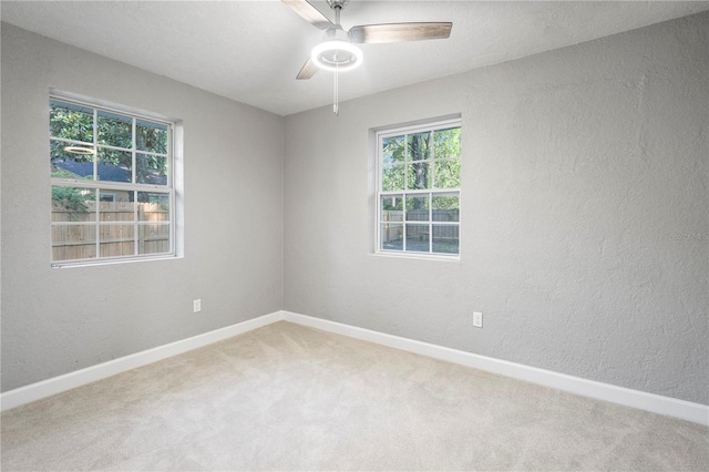 unfurnished room with plenty of natural light, carpet floors, and ceiling fan