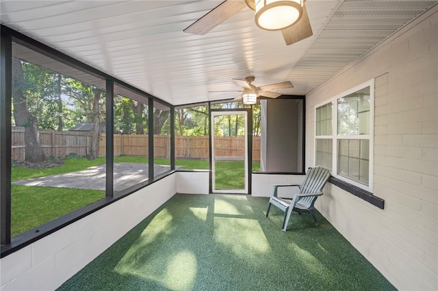 unfurnished sunroom with ceiling fan and vaulted ceiling