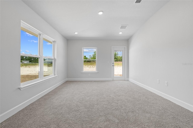 empty room with recessed lighting, visible vents, baseboards, and light colored carpet