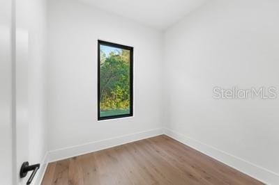 spare room with wood-type flooring