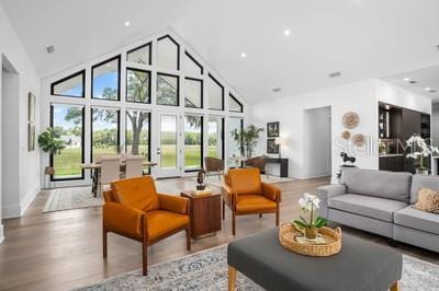 living room with high vaulted ceiling and light hardwood / wood-style floors