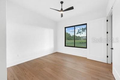 spare room with hardwood / wood-style flooring and ceiling fan