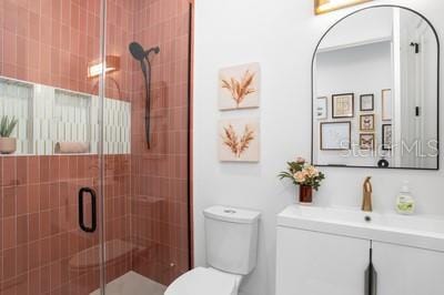 bathroom with vanity, toilet, and a shower with shower door