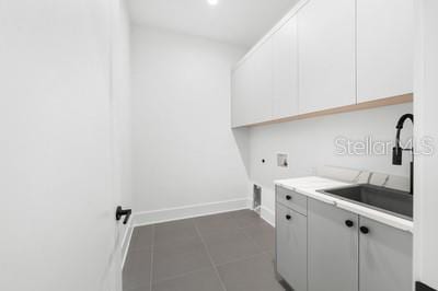 19010 SW 21st Pl, Newberry, FL 32669 - laundry area featuring sink, dark tile patterned flooring, cabinets, hookup for a washing machine, and electric dryer hookup