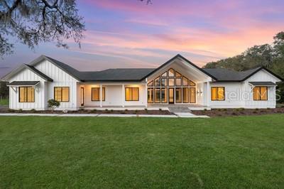 19010 SW 21st Pl, Newberry, FL 32669 - back house at dusk featuring a yard